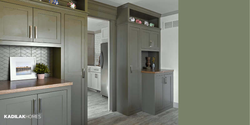 This dark green and gray. paint color brings lots of warmth to the built-in cabinets we built outside of our clients' scullery. Described as "a hint of gray brings a polished finish to this dark moss green."