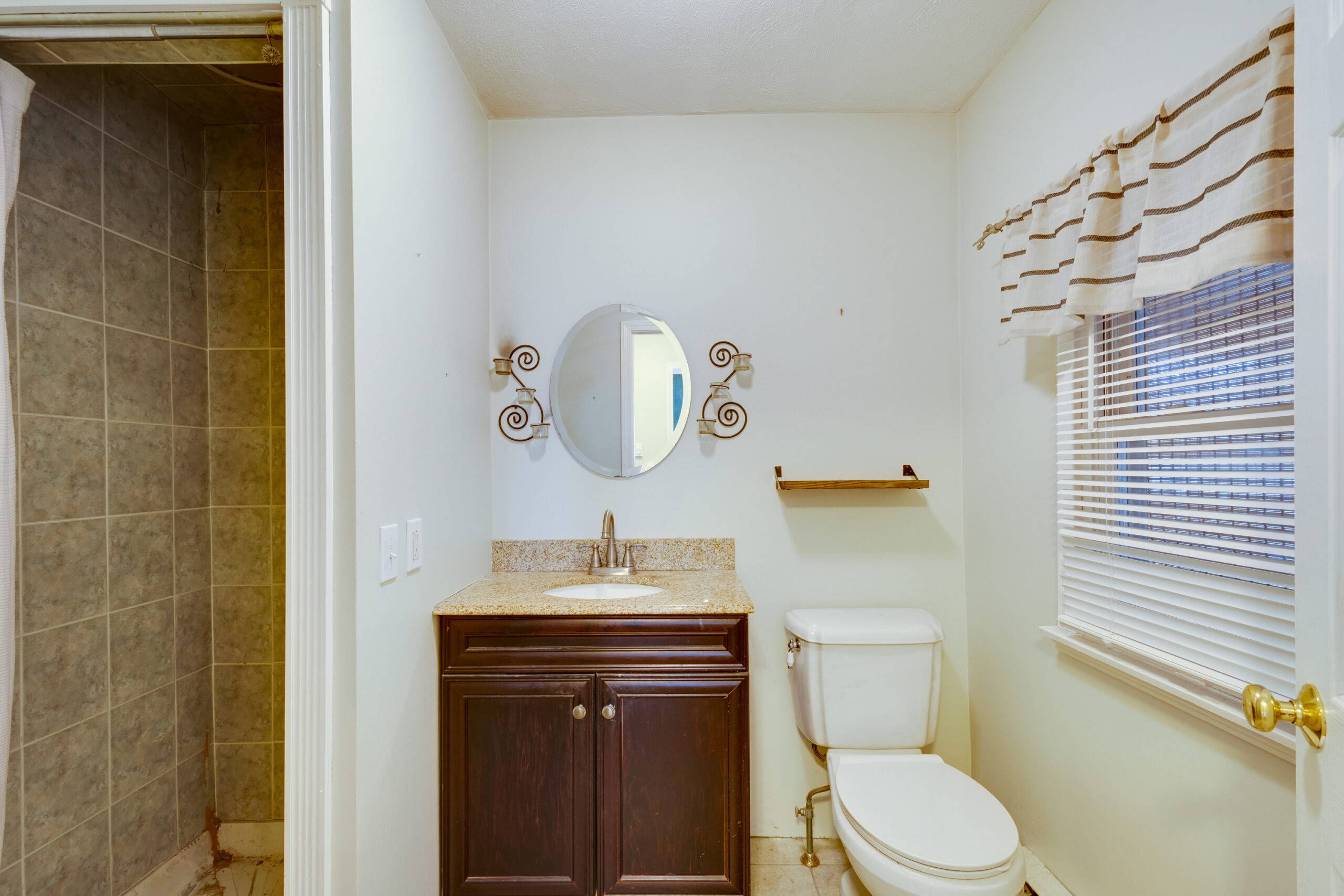 Before image of a bathroom in a vintage New England home featuring dated fixtures and a cramped layout prior to renovation.