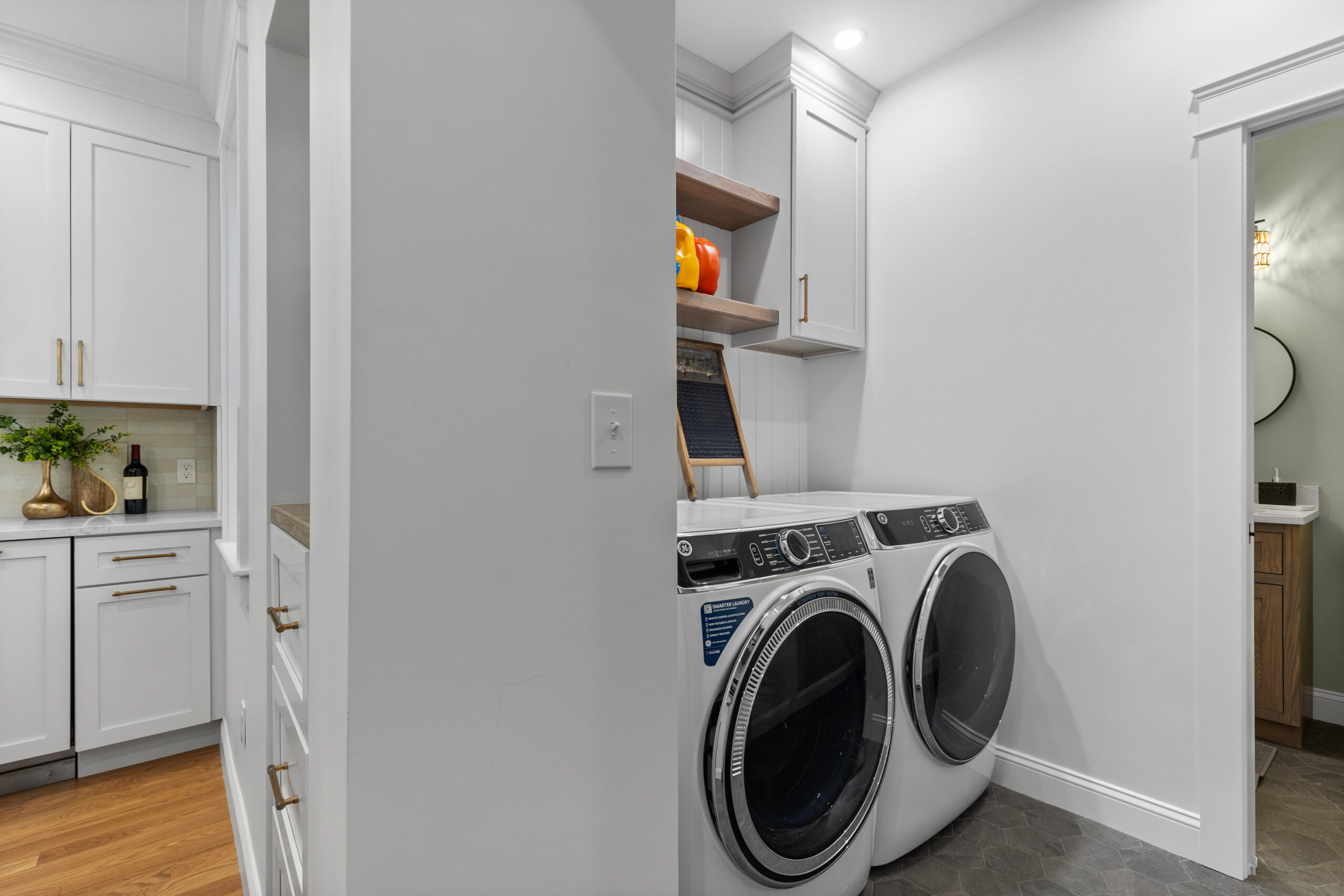 Renovated laundry room in a vintage New England home featuring modern washer and dryer, custom cabinetry, and a sleek, organized space.