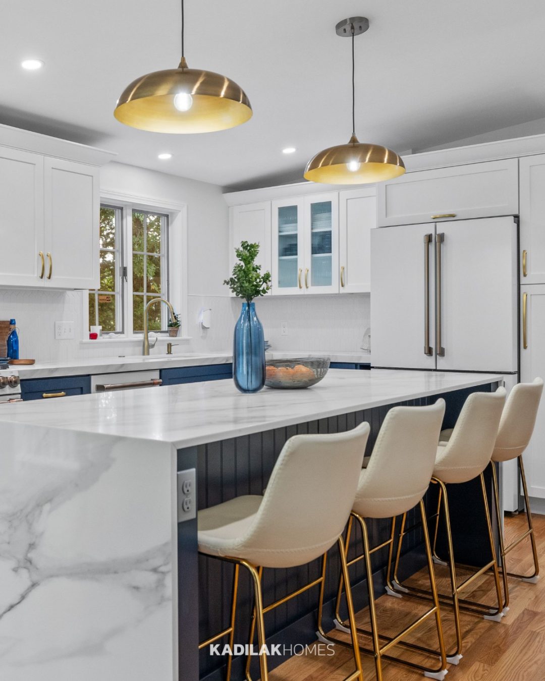 Kudos LED Pendant from Amazon in a brushed brass finish hanging above a modern kitchen island with white quartz countertops.