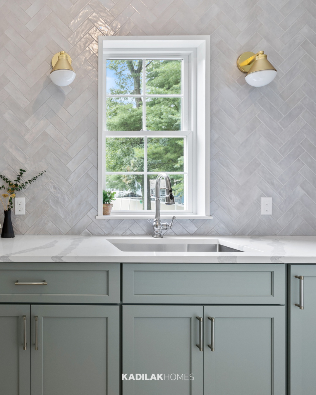 Blair Wall Sconce by Rejuvenation in a satin brass finish with an opal glass shade mounted on either side of a kitchen window.