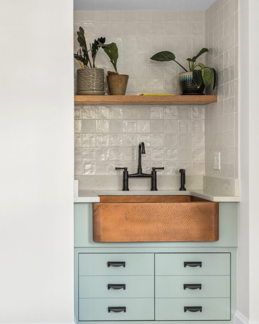 Laundry room cabinet painted in Palladian Blue HC-144 by Benjamin Moore with copper farmhouse sink, neutral tile backsplash, and soft coastal aesthetic often seen in palladian blue bathroom designs
