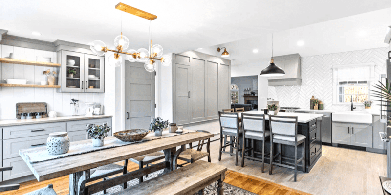 Small kitchen with square island, bar cabinets with glass doors, Pottery Barn curved arm sconce in brass, crate and barrel maddox bell pendant