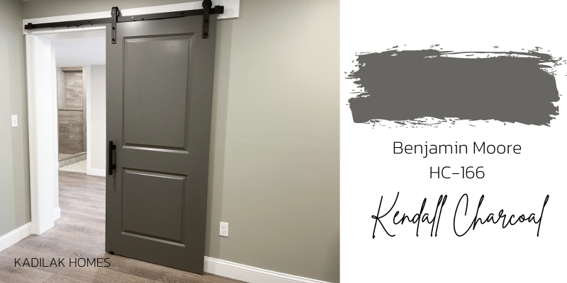 Basement office barn door painted Benjamin Moore Kendall Charcoal HC-166 with a view to the basement bathroom
