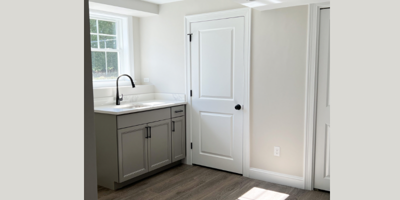 Basement wet bar with gray cabinets and Kohler Simplice faucet