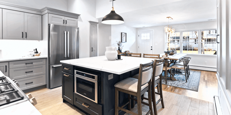 Small kitchen design ides with square island and gray cabinets. Crate and barrell Maddox black bell pendant large, brushed gold sputnik chandelier