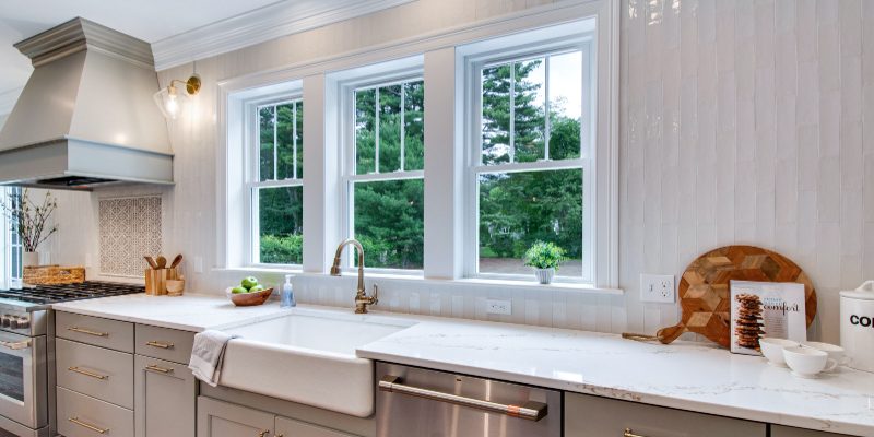 kitchen next to family room, kitchen with wood island, taupe cabinets and wood island, chevron coffered ceiling, open kitchen and family room, kohler artifacts single handle faucet modern brass, benjamin moore carolina gull, fireclay tile kabuki sphere, kohler whitehaven apron sink