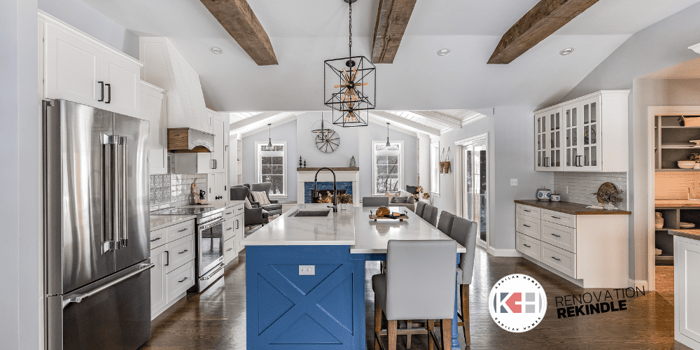 wood ceiling beams, fireplace with blue tile, blue kitchen island, 2 tiered island, gray counter stools, black spiral faucet, fireplace with windows on each side, kitchen open to family room, kitchen open to living room, fireplace wall ideas, fireplace with blue tile, fireplace bench