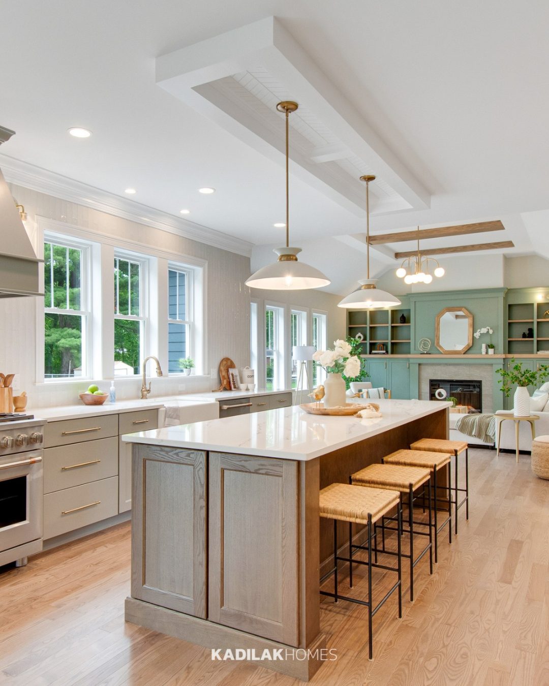 Giles Metal Dome Pendant by Etta Avenue with a white metal shade and warm brass accents hanging above a large kitchen island.