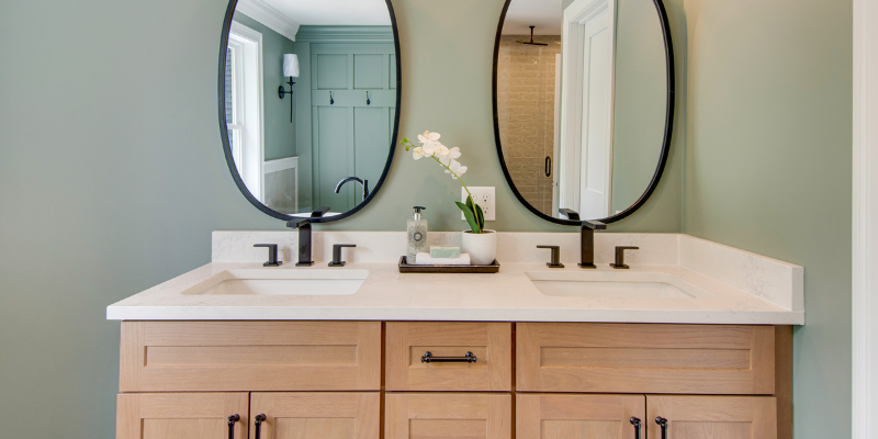 main bathroom with light wood double vanity, towel nook, black faucets, quartz counters, towel nook