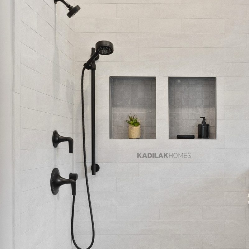 Modern shower with dual built-in niches and matte black fixtures, featuring minimalist decor.