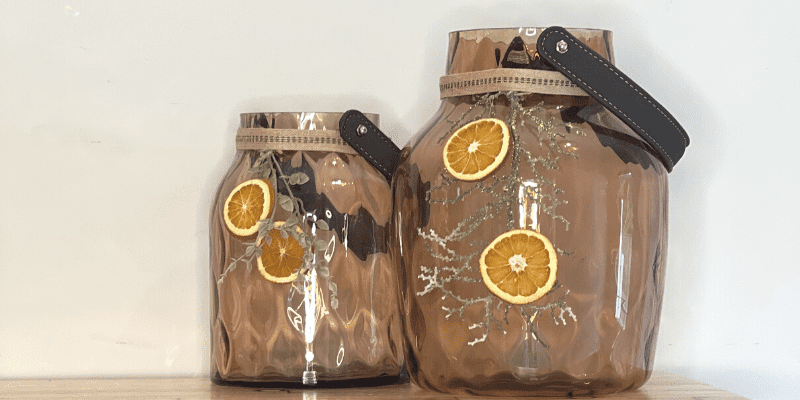 Dried orange slices with greens on amber vase