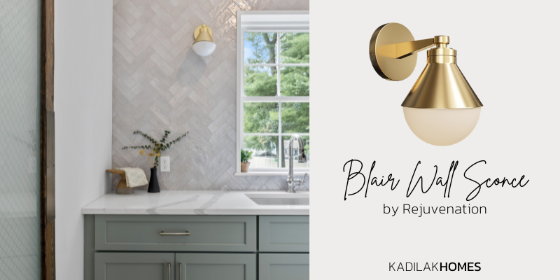backsplash with matte gray herringbone subway tile, rejuvenation blair wall sconce, green cabinets, quartz countertop, wood door with frosted glass, blair sconce in aged brass