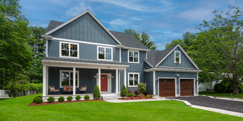 James Hardie siding evening blue, Benjamin Moore Iron Ore Red front door, stained wood garage doors
