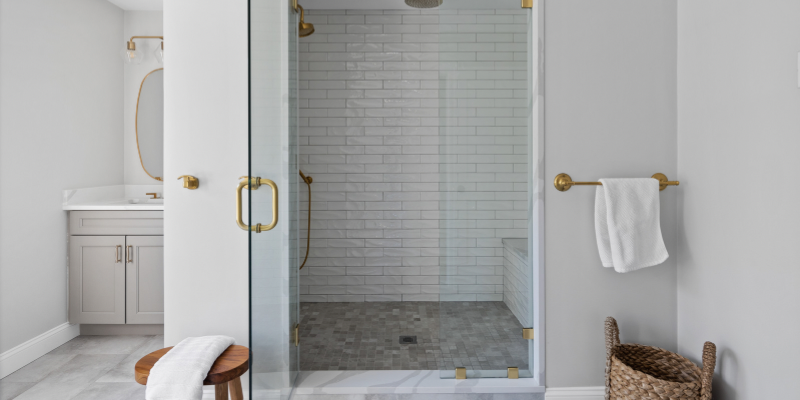 Primary bathroom with white and soft gray color palette and brushed gold fixtures