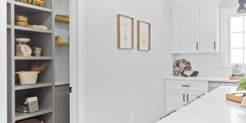 Stylish kitchen with built-in gray open shelving and modern white cabinets.
