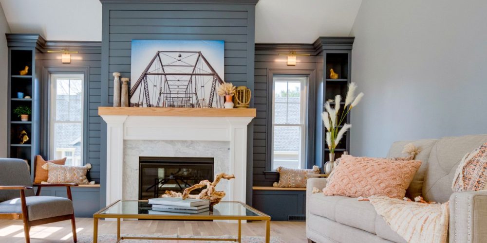 Built-in shelves and shiplap fireplace wall painted in Ocean Floor by Benjamin Moore, featured in The Cape House by Kadilak Homes.