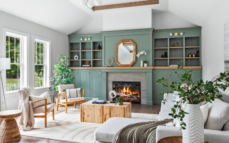 A modern living room with dark wood built-ins, an oak coffee table, and natural green elements that introduce warmth and texture into the minimalist space.