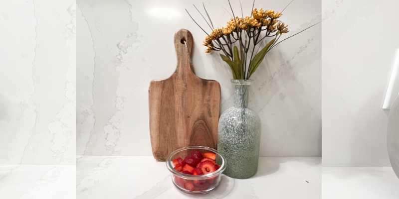 Green flower vase with cutting board and bowl of fresh strawberries for fresh frosting recipe, Valentine's Day treat
