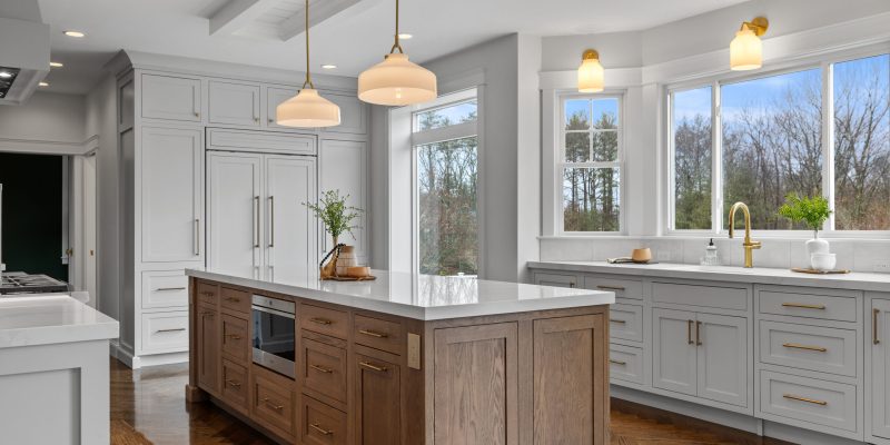 kitchen with oak wood island, paneled appliances, inset cabinets, neutral color scheme, henry sconces, henry pendants, odd shaped kitchen, weird kitchen layout, kitchen sink in bay, large picture window, benjamin moore Cloud Cover OC-25, kohler artifacts kitchen faucet, kohler artifacts bar faucet