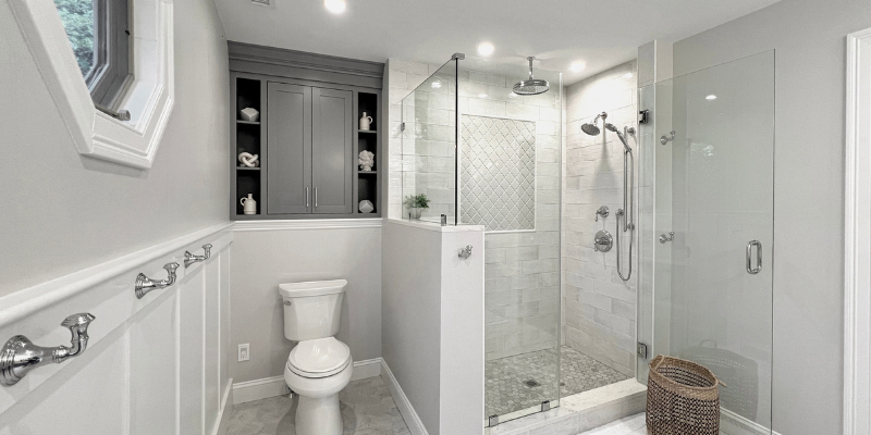 Anatolia Soho beveled arabesque tile in Gallery Grey, Kohler Functional 10" rain head, kohler devonshire shower trim, kohler chrome shower, monopole 5x14 moon tile, primary shower ideas, shower with half wall, toilet half wall, storage over toilet, cabinet over toilet ideas, sherwin williams serious gray, benjamin moore shoreline 1471
